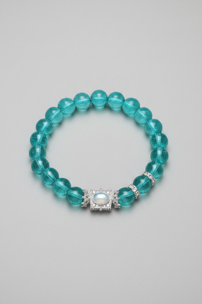 Turquoise beaded bracelet with a silver clasp on a gray background