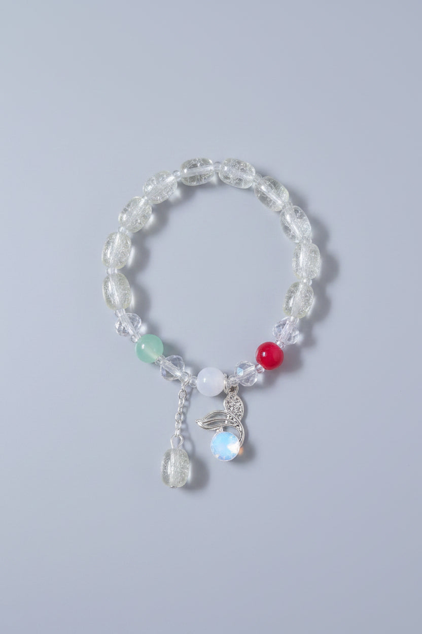 Light green beaded bracelet with colorful charms on a light gray background