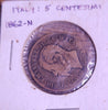 Old coin with detailed design on a wooden surface