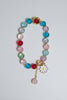 Colorful beaded bracelet with a daisy charm on a light background