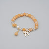Bracelet with beads and a charm on a textured surface