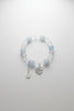 Bracelet with blue and clear beads on a gray surface
