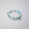 Beaded bracelet with blue and clear beads on a gray background