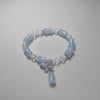 Beaded bracelet with blue and clear beads on a gray background