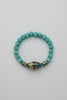 Beaded bracelet with blue beads on a gray fabric background