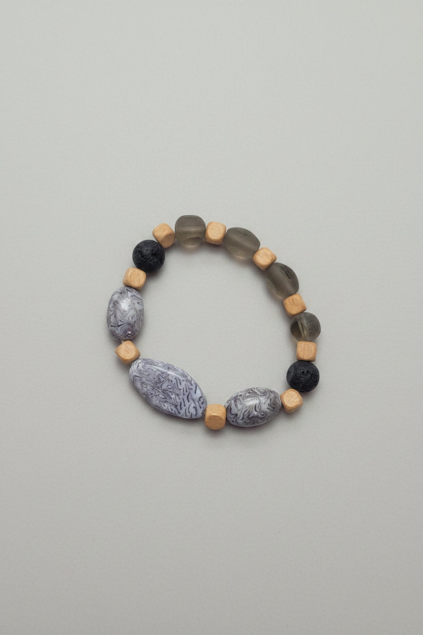 Bracelet made of natural stone beads on a grey surface