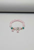 Pink beaded bracelet with charms on a white background