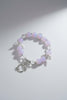 Bracelet with pink beads and silver butterfly charms on a light gray background