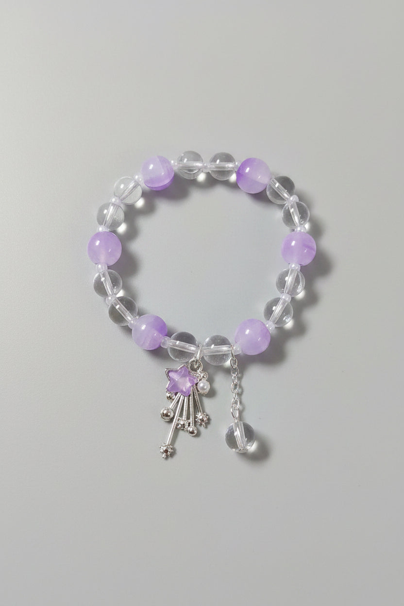 Bracelet with purple beads and a star-shaped charm on a light gray background