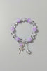 Bracelet with purple beads and a star-shaped charm on a light gray background