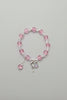 Beaded bracelet with pink and clear beads and a silver charm on a gray background